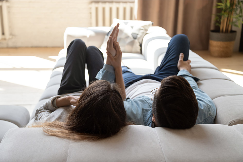 Man & Woman Lying On Couch